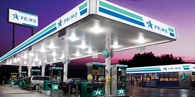 Tankstelle mit lebendigen, blau und grün hinterleuchteten Grafiken und Beschilderungen
