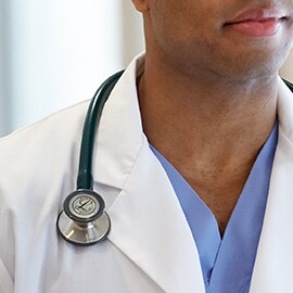 Littmann Stethoskop richtig getragen, so dass es außerhalb des Kragens des weißen Arztkittels liegt und die Schläuche nicht den Hals des Klinikers berühren.