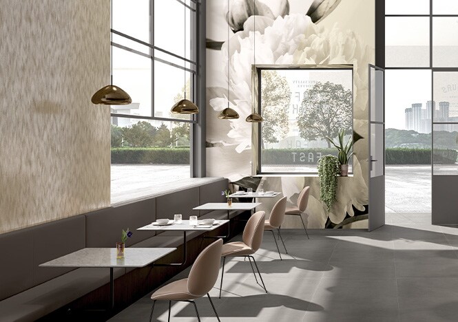 Caféeinrichtung in neutralen Tönen, Wände mit gedruckten Blumenmotiven auf Grafikfolie.