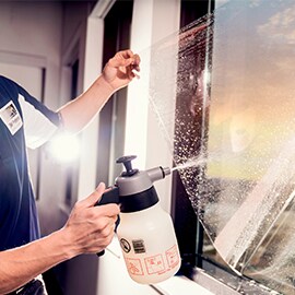 Eine Person, die 3M™ Fensterfolien für Gebäude installiert