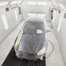 Ein Auto in einer Lackierkabine im forcierten Trocknungsprozess
