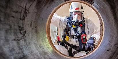 Ein Arbeiter, der eine 3M Atemschutzmaske und einen Helm trägt
