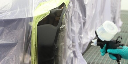Lackierer beim Polieren eines Karosserieteils
