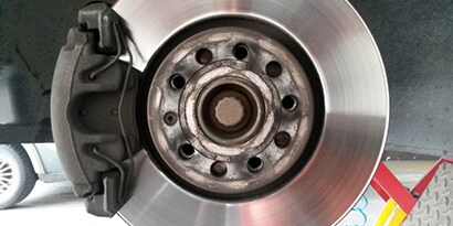 Eine Bremsscheibe und eine Bremszange symbolisieren thermische Herausforderungen bei Metallen.
