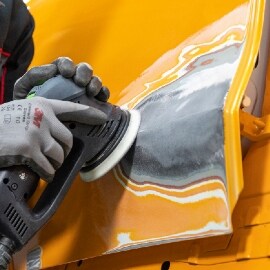 Techniker schleift den Bereich der Spachtelstelle