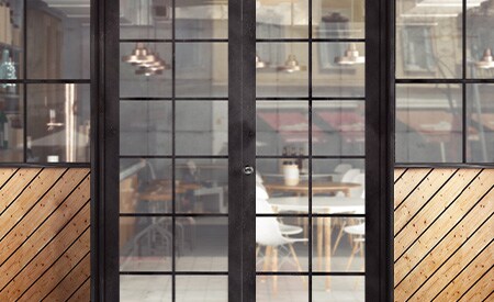 Außenansicht eines Restauranteingangs mit Blick durch Glastüren und Fenster

