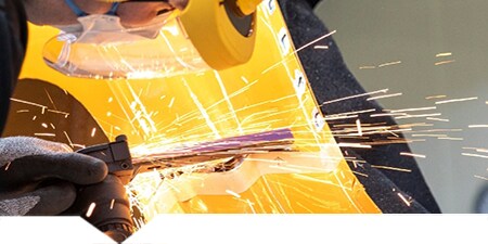 Lackierer beim Trennen eines metallischen Karosserieteils
