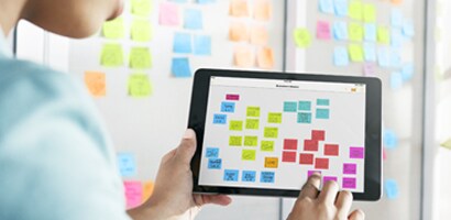 Eine junge Frau verwendet die App, um ein Kanban-Board einzurichten und zu verwenden.