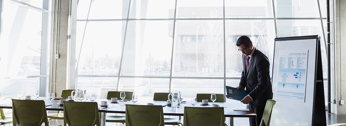 Ein Mann bereitet sich auf ein Meeting in einem Raum mit großen Fenstern vor – geschützt durch 3M Fensterfolien
